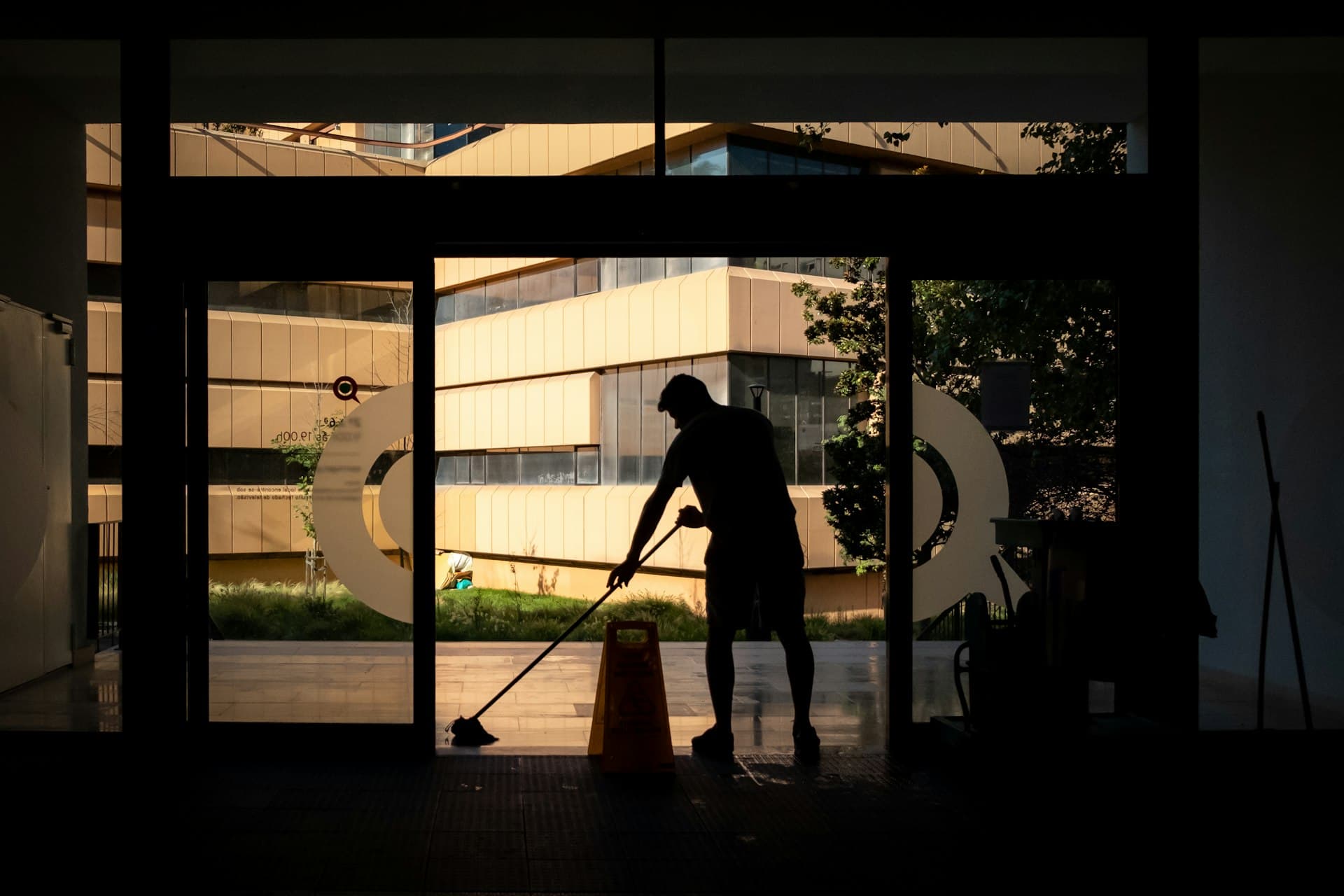A cleaner mopping an office lobby at night