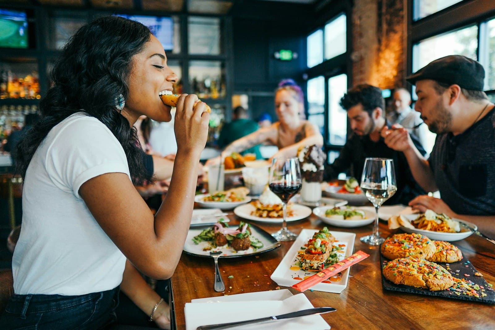 Guests sharing dishes around a full restaurant table
