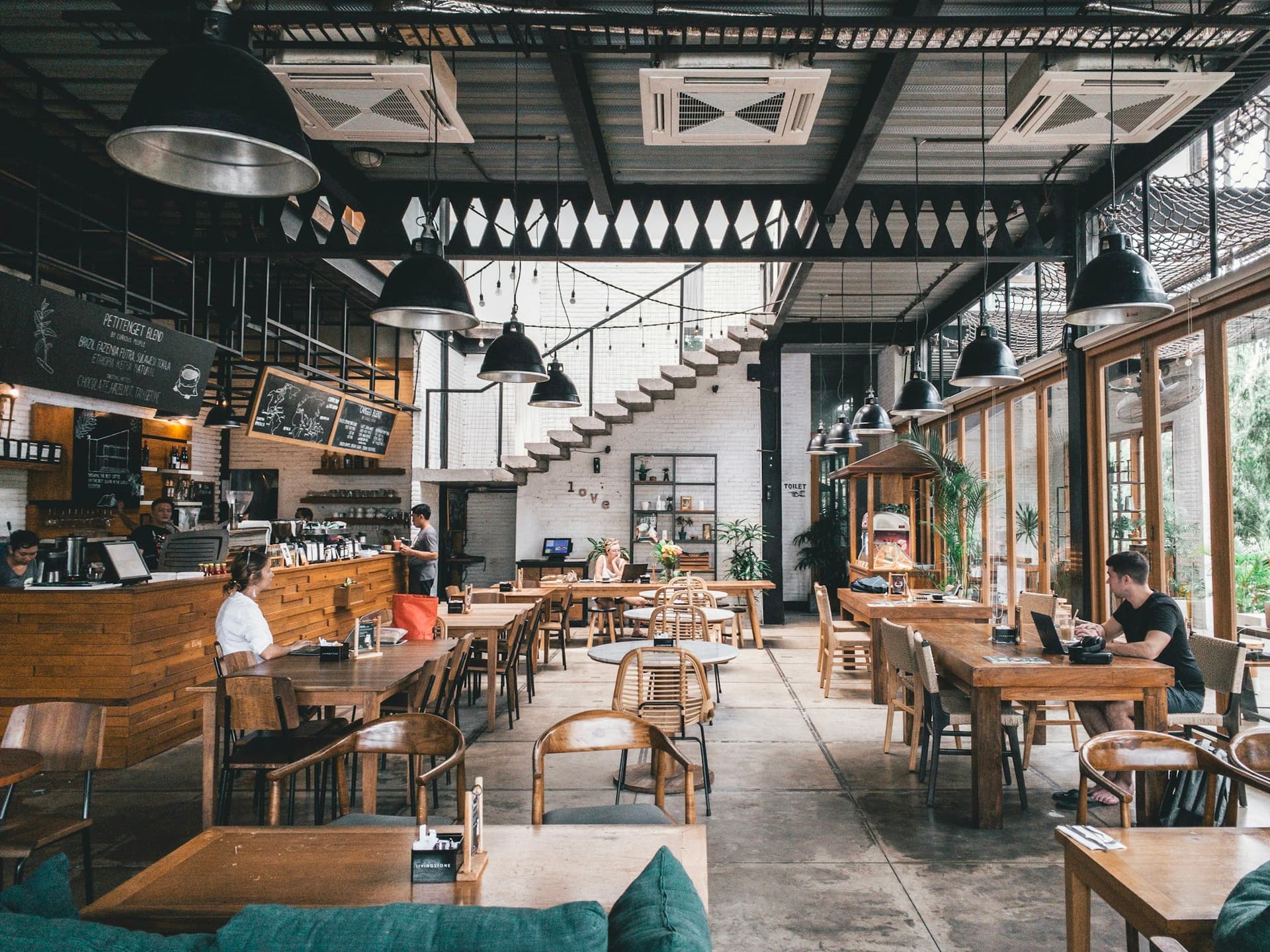 An industrial-style restaurant dining room with warm lighting