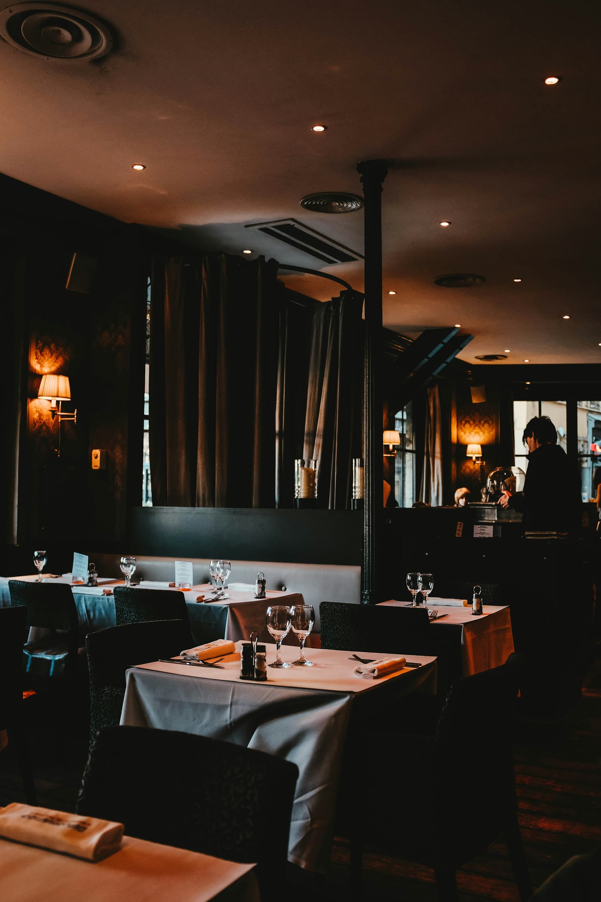A dimly lit restaurant dining room set for service